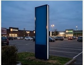 Totem publicitaire rétroéclairé sur un parking commercial